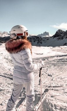 Yüksek dağlar karlı beyaz kış günü. Moda ceket kürk, kar gözlükleri ve kask ile bir kadın. Kayak kız