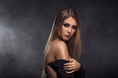 Zarif siyah gece elbisesi içinde güzel bir kadın. Uzun sağlıklı ve parlak saçlar için. Bakım ve güzellik. 