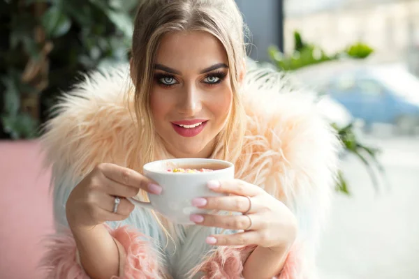 Fröhliches Mädchen trinkt Kaffee im Café. — Stockfoto