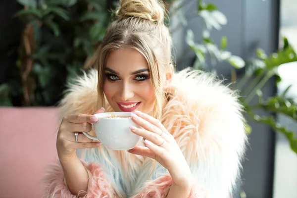 Szczęśliwa dziewczyna picia kawy w kawiarni. — Zdjęcie stockowe