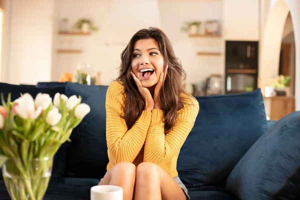 Lachende vrouw ontspannen op de sofa thuis. — Stockfoto