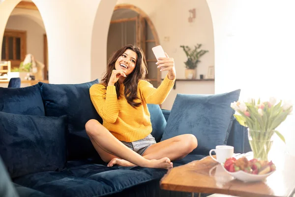 Gelukkig vrouw met behulp van mobiele telefoon thuis. — Stockfoto