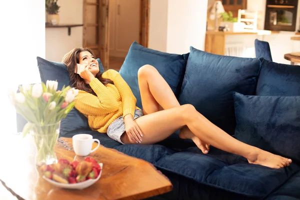 Mujer feliz usando el teléfono móvil en casa. — Foto de Stock