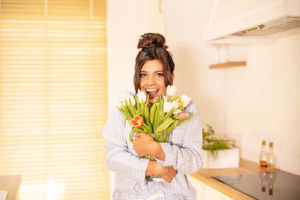 Vrouw met bloemen, glimlachend naar de camera. — Stockfoto