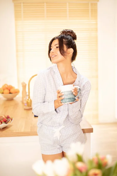 Woman drinking coffee at home, relaxing.