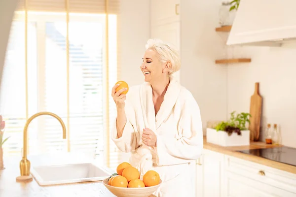 Niedliche Frau tut Orangensaft. — Stockfoto