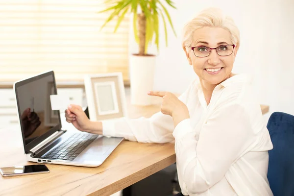 Happy businesswoman sitting at desk in office. — Stock Photo, Image