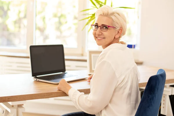 Empresária feliz sentada na mesa no escritório . — Fotografia de Stock