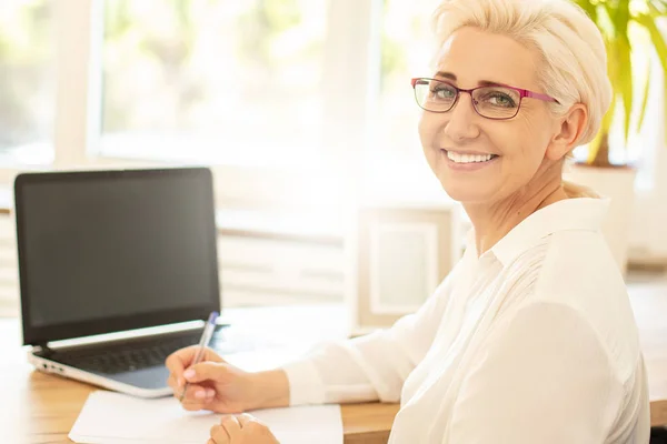 Happy affärskvinna sitter vid skrivbord i office. — Stockfoto