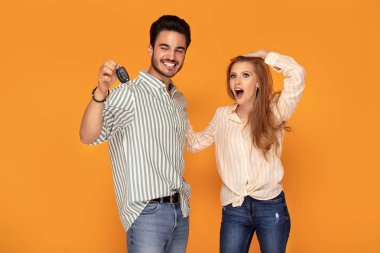 Araba anahtarı ile mutlu genç çift.