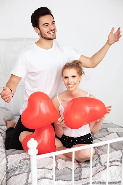 Pareja posando con globos rojos del corazón . — Foto de Stock