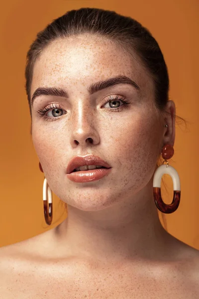 Menina de gengibre elegante usando brincos . — Fotografia de Stock