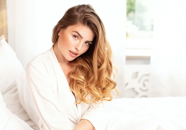 Menina de gengibre feliz sorrindo, relaxando na cama . — Fotografia de Stock