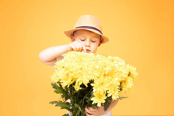 Glückliches Kind mit Sommermütze und Blumen. — Stockfoto