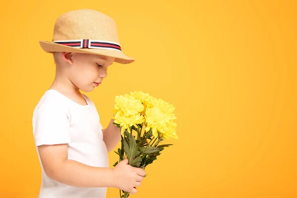 Glückliches Kind mit Sommermütze und Blumen. — Stockfoto