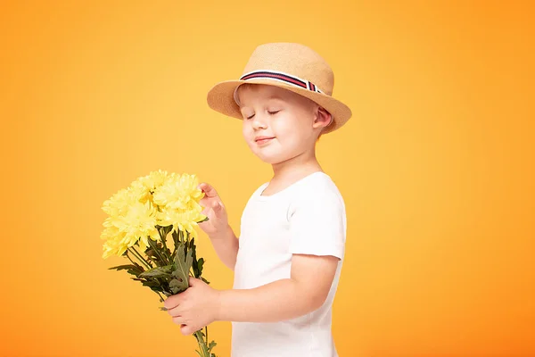 Glückliches Kind mit Sommermütze und Blumen. — Stockfoto