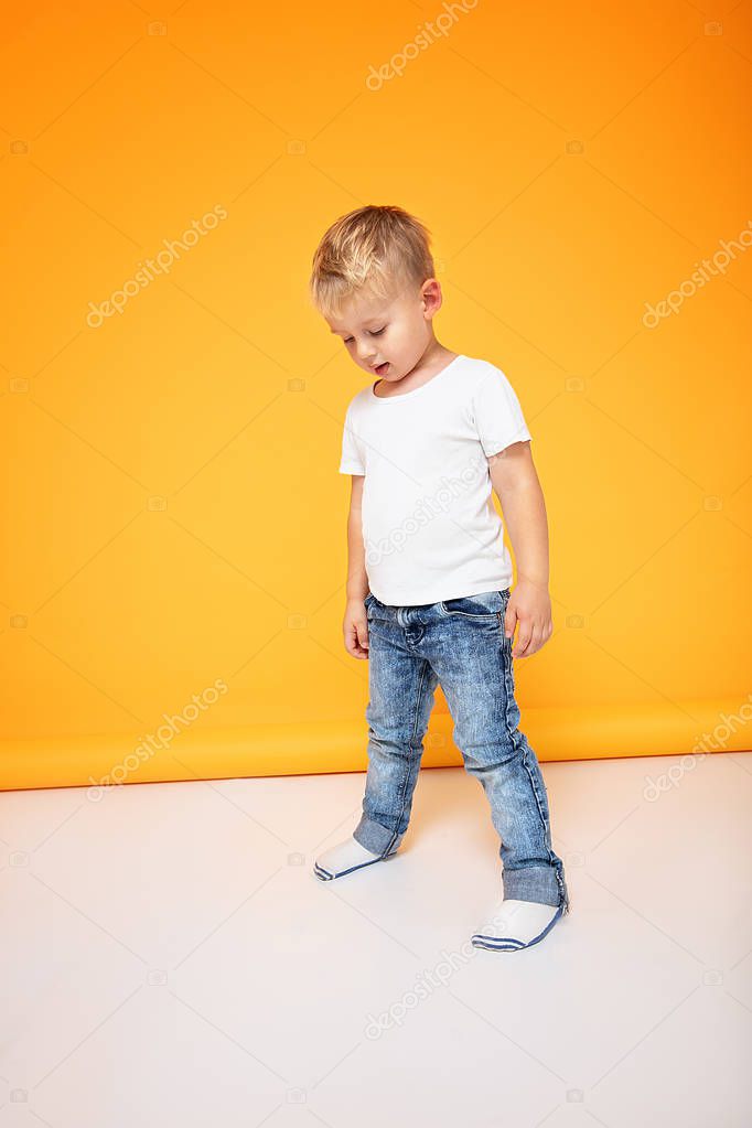 Fashionable little boy posing in jeans.
