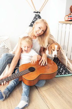 Küçük çocuk annemle gitar çalıyor .