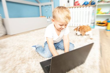 Evde dizüstü bilgisayar kullanan çocuk.