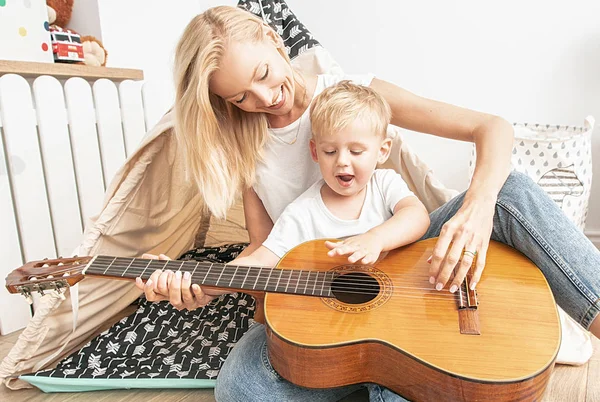 Kleiner Junge spielt mit Mama auf der Gitarre . — Stockfoto