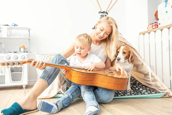 Kleiner Junge spielt mit Mama auf der Gitarre . — Stockfoto