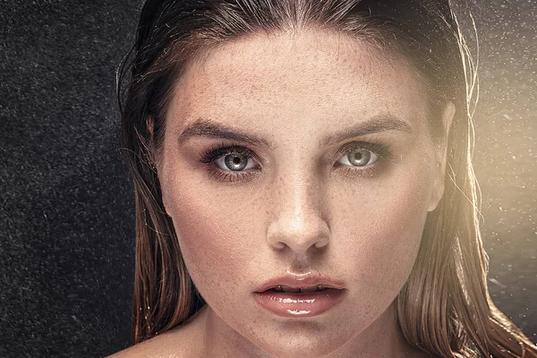 Woman with freckles on face and long wet hair.