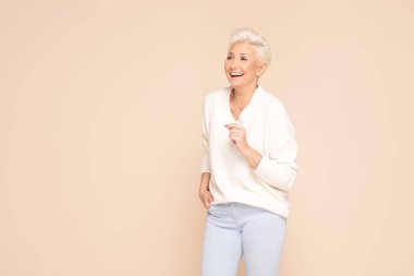 Rahat süveter içinde gülümseyen yetişkin kadın..