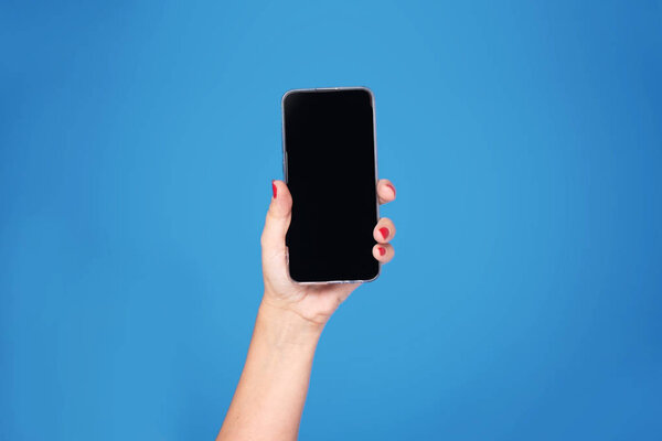 рука с мобильным телефоном на синем фоне
.