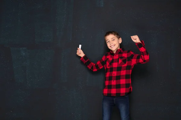 Adolescente menino em xadrez camisa sobre preto giz bordo . — Fotografia de Stock