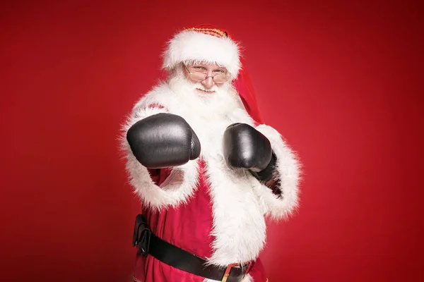Real Santa Claus in boxing gloves on red background. — Stock Photo, Image