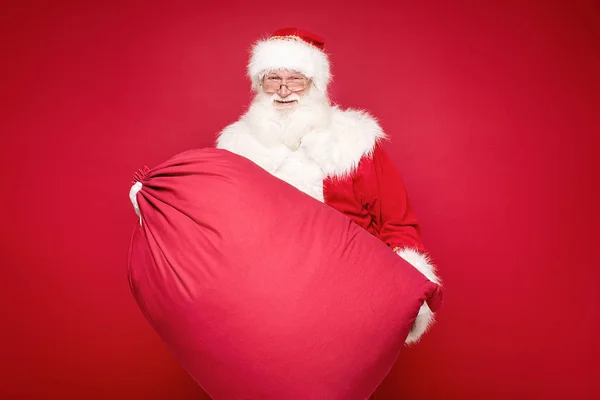 Real Santa Claus sonriendo, sosteniendo gran bolsa de regalo . —  Fotos de Stock