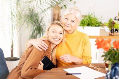 Kıdemli güzel kadın torunuyla evde vakit geçiriyor, sarılıyor, konuşuyor, gülümsüyor..