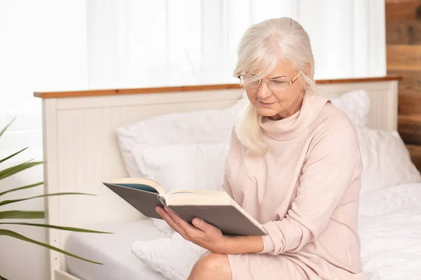 Senior Kvinna Läser Koncentrerad Bok Pensionärshem Fritid — Stockfoto
