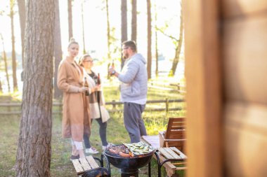 Bir grup arkadaş et ve sebze ızgara yaparken eğleniyor, bbq partisinin tadını çıkarıyorlar. Mutlu adam ve kızlar dışarıda barbeküde bira pişirir ve içerler..