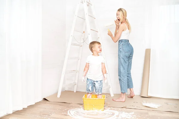 Madre Pintando Pared Mientras Pequeño Hijo Juega Con Pintura Nuevo —  Fotos de Stock