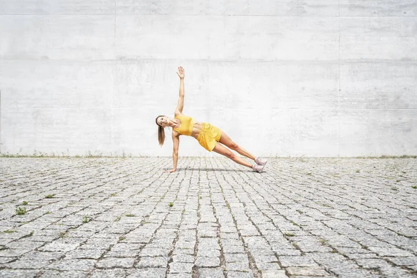 Spor giyim sektöründe esneme sporu yapan beyaz bir kadın. Sağlıklı yaşam tarzı kavramı.