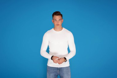 Genç yakışıklı adam şık kıyafetler giyiyor, kameraya bakıyor. Bir sürü kopyalama alanı.