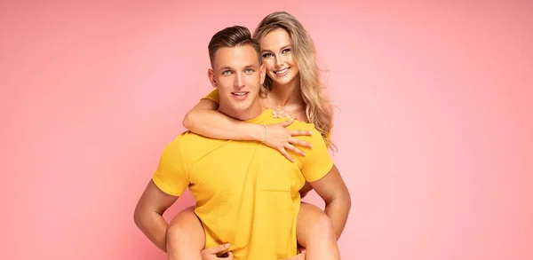 美しい若いカップルの笑顔 ピンクのパステルスタジオの背景にポーズ — ストック写真