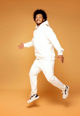 Yakışıklı Afrikalı bir adamın şık eşofman giydiği bir stüdyo fotoğrafı..