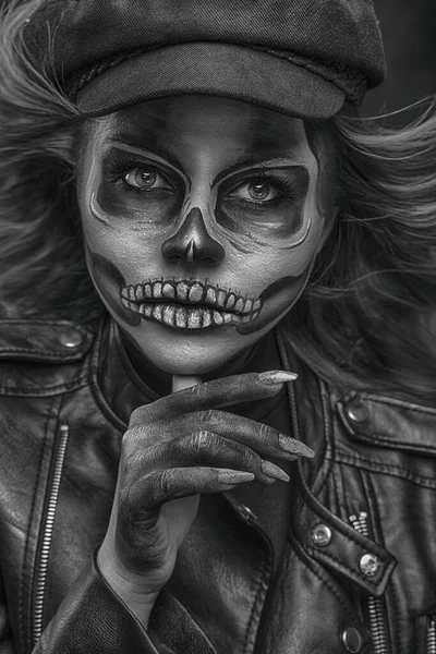 Portrait of a woman with skull makeup over black studio background. Halloween costume and make-up.