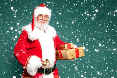 Elinde hediye kutuları olan gerçek Noel Baba 'nın portresi. Yeşil stüdyo geçmişi.