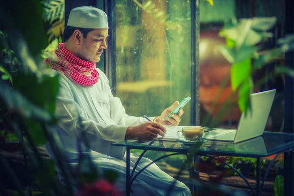 Pakistanlı Müslüman Adam Kahve Dükkanında Dizüstü Bilgisayar Cep Telefonuyla Çalışıyor — Stok fotoğraf