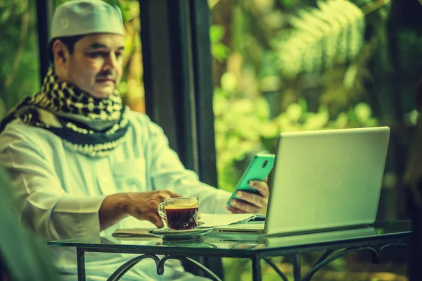 Pakistaanse Moslim Man Werkt Laptop Mobiele Telefoon Coffeeshop — Stockfoto