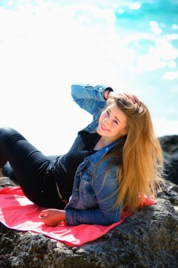 Plaj Bahamaları 'ndaki taşın üzerine uzanmış güzel bir kadının portresi.