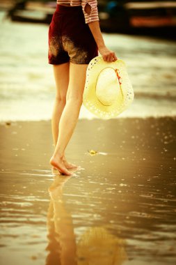 Sahilde yürüyen Asyalı kadın.