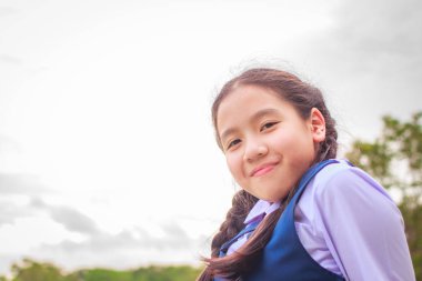 Mutlu kız okul üniforması ve bahar bahçe içinde gülümseyen.