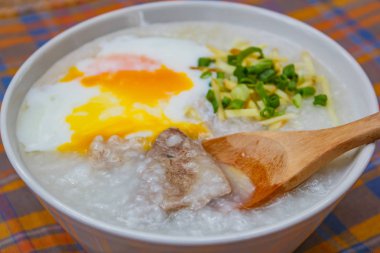 Pirinç lapası yumuşak haşlanmış yumurta, zencefil ve doğranmış taze soğan, Tay tarzı ile.