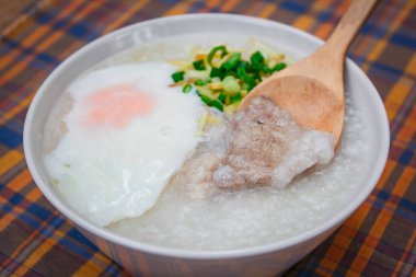 Pirinç lapası yumuşak haşlanmış yumurta, zencefil ve doğranmış taze soğan, Tay tarzı ile.