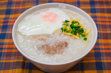 Pirinç lapası yumuşak haşlanmış yumurta, zencefil ve doğranmış taze soğan, Tay tarzı ile.