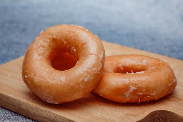 Donut toppint cukrem na bílé barevné desce . — Stock fotografie